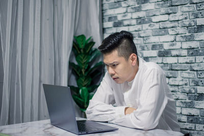 Woman using mobile phone while sitting on table