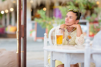 Portrait of woman drinking beer at beach cafe