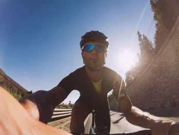 Low angle view of man cycling against clear sky