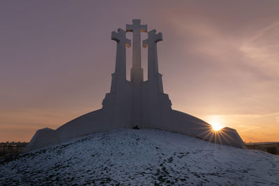 Low angle view of cross against sky during sunset