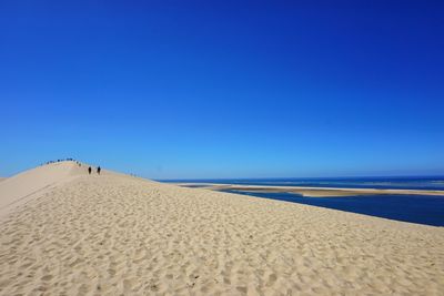 Scenic view of beach against clear blue sky