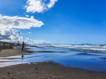 Scenic view of beach against blue sky