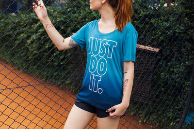 Low section of girl standing on fence