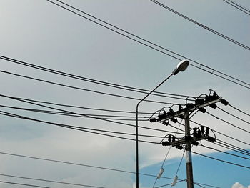 Low angle view of electricity pylon against sky