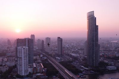 Aerial view of buildings in city during sunset