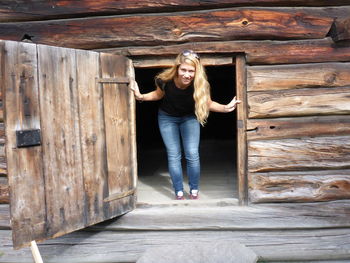 Portrait of smiling young tourist standing by door at museum