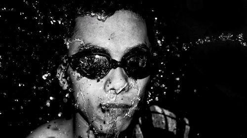 Close-up of water splashing on man's face