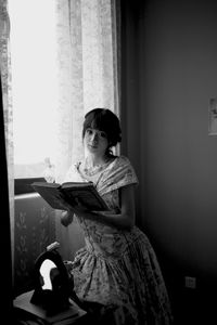 Girl sitting on book at home