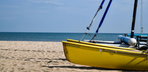 Sailboat moored on beach against sky