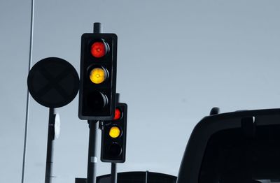 Low angle view of illuminated stoplight against clear sky