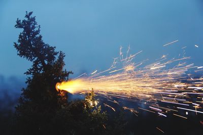 Low angle view of illuminated fire against sky at night