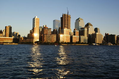 River by buildings against clear sky in city