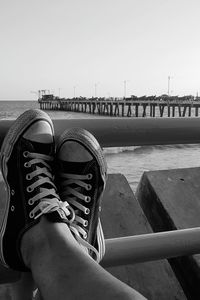 Low section of person by sea against sky