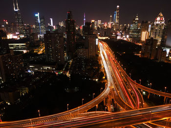 High angle view of illuminated street amidst buildings at night