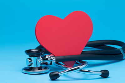 Close-up of heart shape on table against blue background