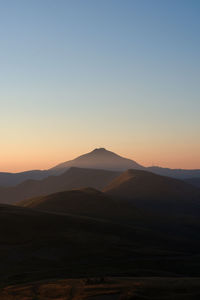 Scenic view of mountains against clear sky during sunset