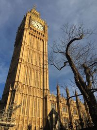 Low angle view of clock tower against cloudy sky