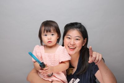 Portrait of smiling young woman holding thermometer at home