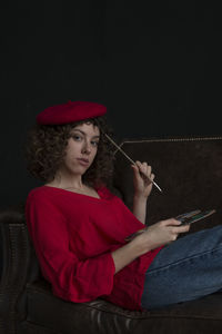 Young woman holding red while sitting at home