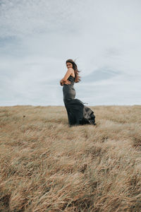 Woman standing on field against sky