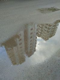 Reflection of city in puddle on road