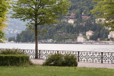 Scenic view of river by city against mountains