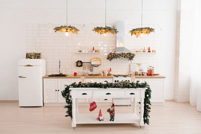 Interior of a bright kitchen with a table in a scandinavian style island, decorated for christmas