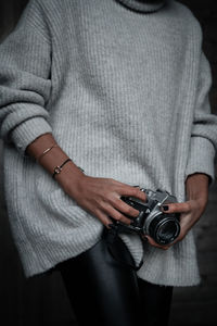 Midsection of woman holding camera