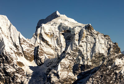Low angle view of snow covered mountain against clear sky