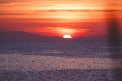 Scenic view of sea against romantic sky at sunset