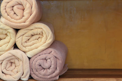 Close-up of rolled up towels on shelf at spa