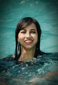 Portrait of a smiling young woman swimming in pool