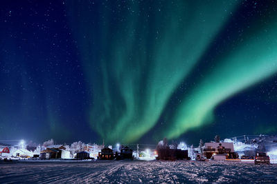 Illuminated city against sky at night