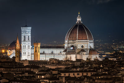 Cathedral amidst buildings in city at night