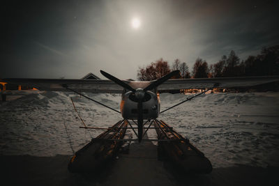 Biplane against sky at night during winter