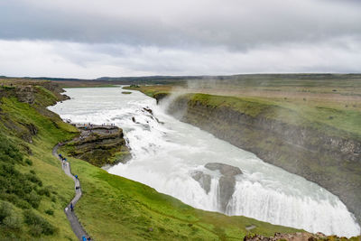 Scenic view of waterfall against sky