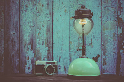 Close-up of electric lamp against blue wall