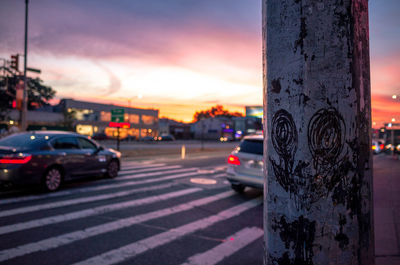 Close-up of cars on road against sky during sunset