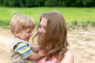 Smiling mother with son embracing outdoors