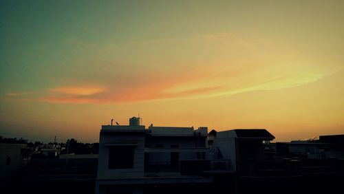 Silhouette buildings against sky during sunset