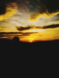 Silhouette landscape against sunset sky