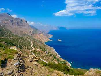 Scenic view of sea and mountains against blue sky