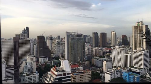 Skyscrapers against cloudy sky