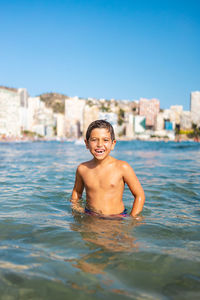 Funny kid into the water on an urban beach