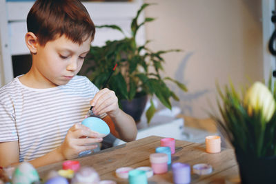 Cute little boy colouring eggs for easter