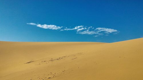 Scenic view of desert against blue sky