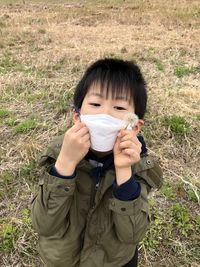 A smiling child looking at the camera with a mask.