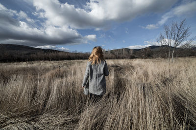 Woman standing on field against sky