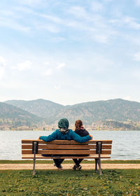 Couple sitting on bench looking at view