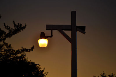 Low angle view of illuminated street light against sky during sunset